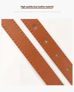 Detail of high-quality brown faux leather belt with orange stitching and round holes