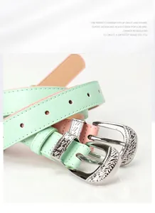 Detail of mint green and pink thin belts with vintage floral engraved silver buckles