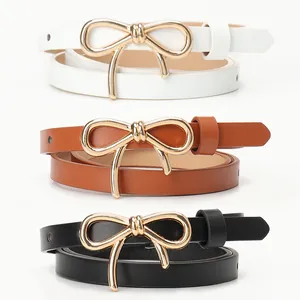 Three elegant skinny belts in black, white, and brown with golden bow buckles