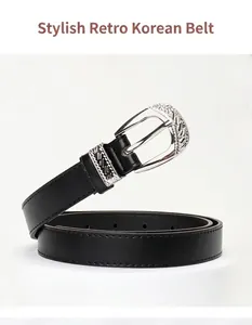 Macro shot of black leather belt with detailed vintage floral engraved silver buckle