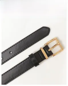 Close-up of black leather belt with golden pin buckle and neat reinforced stitching