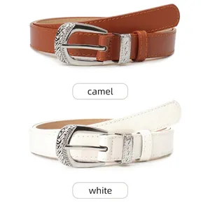 Detail of western vintage engraved silver buckles on camel and white leather belts