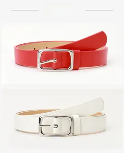 Detail view of thin red and white leather belts featuring classic silver metal pin buckles
