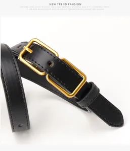 Detail of black leather belt with gold rectangular buckle and precision stitching
