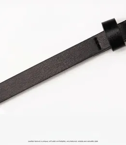 Detalle de cinturón de cuero PU negro mate con textura de lichi y costuras precisas