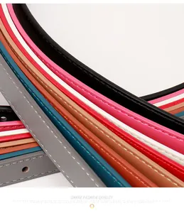 Close-up of colorful thin PU leather belts with fine stitching and polished alloy buckles