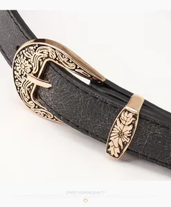 Gros plan d'une ceinture noire en cuir avec boucle dorée à motifs gravés