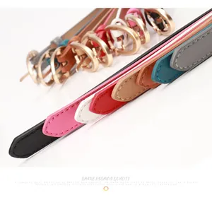 Detail of colorful slim PU leather belts for women with round golden buckles and fine stitching