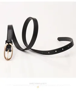 Detail of slim black PU leather belt featuring a golden oval buckle and small bow