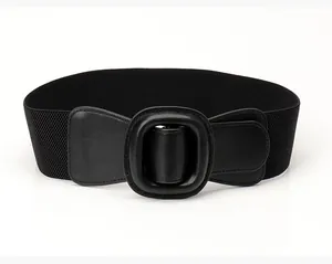 Detail of a wide black elastic corset belt featuring a large matte black buckle on white background