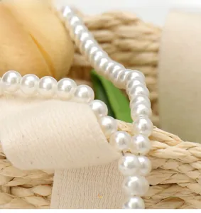 Macro view of elegant white pearls on linen fabric showing smooth texture and luster