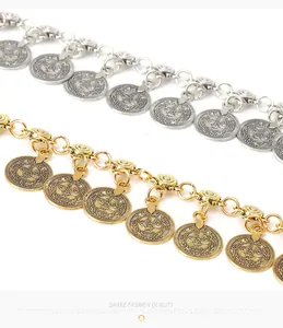 Macro detail of Bohemian metal coin belt pendants in gold and silver finish