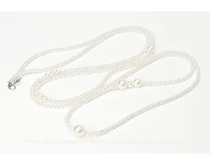 Detailed view of elegant white pearl long necklace with metallic lobster clasp closure