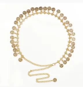Detail of bohemian gold metal chain belt featuring vintage engraved coin charms and clasp