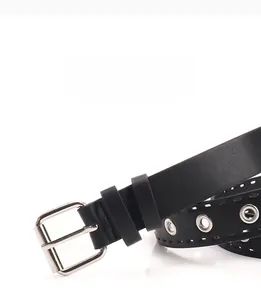 Vue détaillée d'une ceinture punk noire avec œillets métalliques et boucle carrée argent