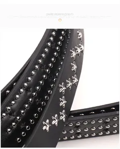 Detail of punk style black leather belt featuring silver star and bead metal studs