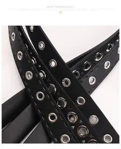 Détail d'une ceinture punk noire avec œillets métalliques argentés et surpiqûres