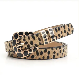 Detail of leopard print belt with gold metal buckle featuring black pebble inlay design