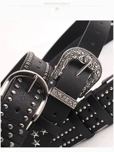 Close-up of black leather belt with silver star studs and engraved vintage buckle