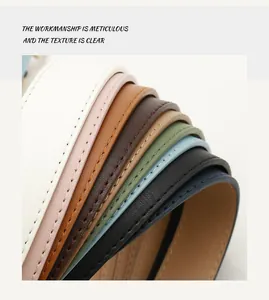 Close-up of minimalist leather belts showing varied colors and fine stitching texture