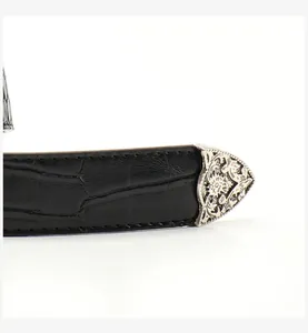 Close-up of black crocodile pattern belt with vintage silver engraved metal tip detailing