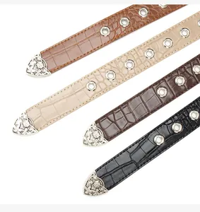 Detail of vintage western belts with crocodile pattern and engraved silver metal tips