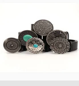 Close-up of vintage Western belts with black leather, embossed buckles, and turquoise stones