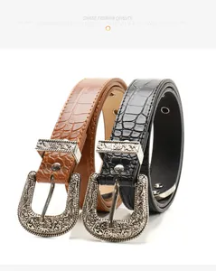 Close-up of vintage Western belt buckles with silver floral engraving and crocodile texture