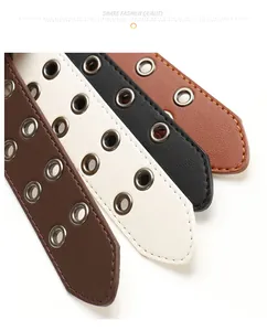 Dettaglio di doppi occhielli in metallo su cinture in pelle nei colori nero e marrone