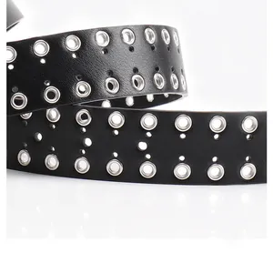 Dettaglio della cintura in pelle nera con tripla fila di occhielli in metallo argento punk