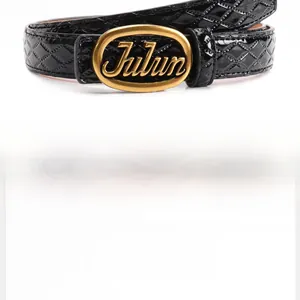 Detail of glossy black quilted belt featuring a gold Julun letter buckle and alloy hardware