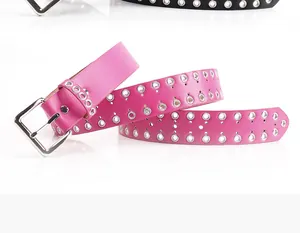 Dettaglio della cintura in pelle rosa acceso con doppi occhielli e fibbia in metallo punk
