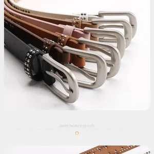 Close-up of Y2K style leather belts with double rows of silver rivets and metal buckles