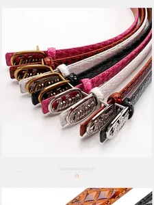 Close-up of colorful quilted patent leather belts with embossed Julun metal buckles