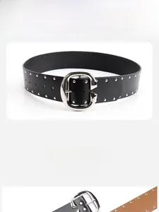 Close-up of black and camel leather belts with double row silver rivets and large G-buckle