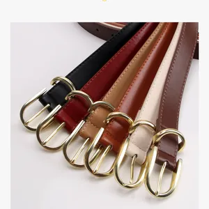 Dettaglio di cinque cinture sottili in pelle da donna con fibbie in metallo dorato lucido