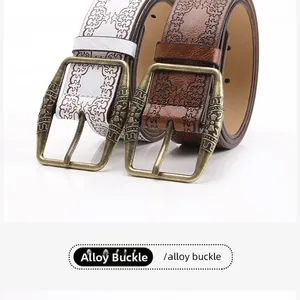 Close-up of vintage embossed leather belts with decorative alloy pin buckles for jeans