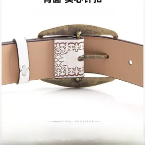 Detail of vintage bronze alloy buckle and embossed PU leather belt with floral patterns