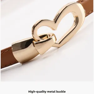 Détail d'une boucle de ceinture en alliage en forme de cœur sur cuir marron de qualité