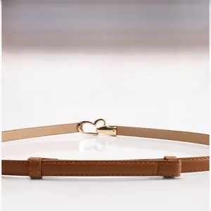 Gros plan d'une ceinture en cuir marron avec une boucle métallique dorée en forme de cœur