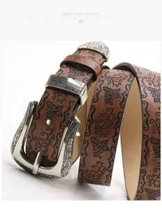 Détail d'une ceinture en cuir vintage avec boucle gravée et motifs de papillons
