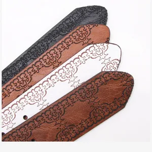 Close-up of four embossed leather belts in black, brown, and white with vintage patterns