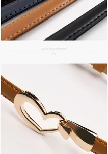 Détail d'une boucle coeur dorée sur fines ceintures en cuir de diverses couleurs avec coutures