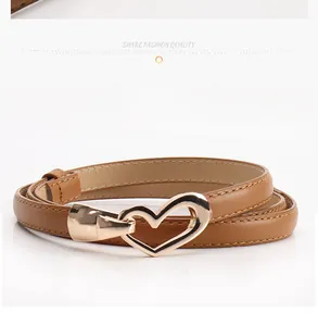 Gros plan sur une fine ceinture marron avec boucle métallique dorée en forme de cœur