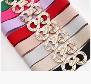 Detail of interlocking gold buckles on elastic waist belts in eight colorful options