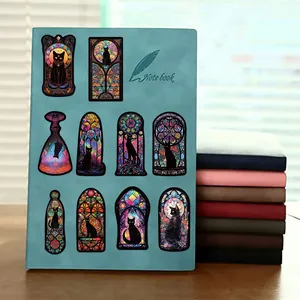 Détail des autocollants de chats gothiques vitraux appliqués sur un carnet de notes
