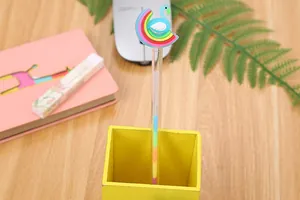 Creative unicorn gel pen with rainbow silicone topper in a wooden pen holder