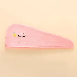 Détail du bonnet de douche en polaire corail rose avec broderie citron et bouton