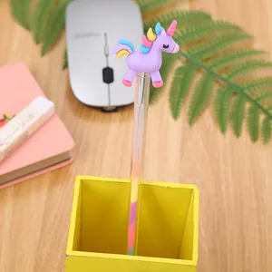 Cartoon unicorn gel pen with multi-color gradient ink on a wooden desk setting