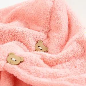 Gros plan sur un tissu polaire corail rose avec deux boutons décoratifs en bois d'ours